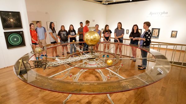 Students surrounding Barlows Planetarium display in campus museum