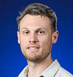portrait of jesse tune with bright blue background